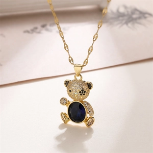 Detailed close-up of a golden teddy bear pendant with micro-pave blue oval gemstone