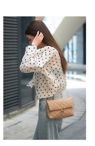 Hellbraune Stepptasche mit Metallverschluss, getragen von einem Model im Outdoor-Streetstyle