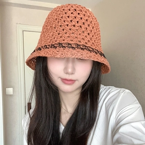 Macro detail of hand-knitted hollow straw bucket hat with black wavy scalloped edges