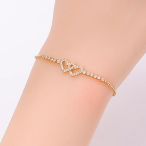 Close-up of golden double heart bracelet with sparkling white zircons and adjustable chain