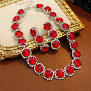 Detail eines Luxus-Schmucksets mit roten runden Edelsteinen und Diamanten auf Rahmen