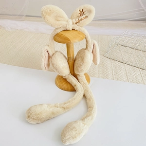Close-up of beige plush ear muffs with long bunny ears and Love embroidery on display