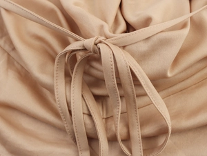 Detail view of khaki sequin two-piece set showing lace-up drawstring and fine stitching
