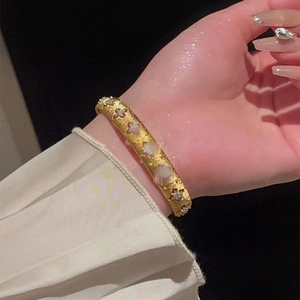 Close-up of gold-plated star pattern bracelet with cubic zirconia on female wrist