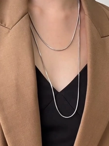 Close-up of double-layer silver snake chain necklace on professional attire outfit