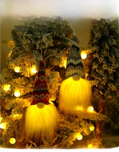 Close-up of lighted Christmas gnomes with warm LED lights and white hanging strings