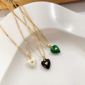 Detailed shot of gold titanium steel heart necklaces with colorful enamel pendants