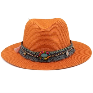 Detail of bohemian straw hat featuring colorful beads, turquoise stone, and ethnic tassels