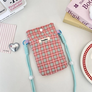 Detail of pink and green plaid fabric mini phone bag with a blue braided strap