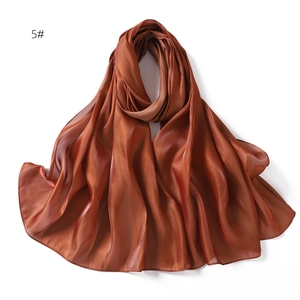 Detail of caramel silk satin scarf showing glossy smooth texture and soft elegant drapes