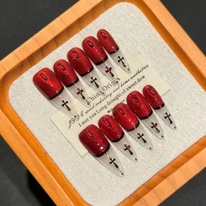 Handmade red cat-eye press-on nails with gothic cross decor and black outline details