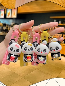 Detailed close-up of four cute cartoon panda PVC keychains with colorful wrist straps