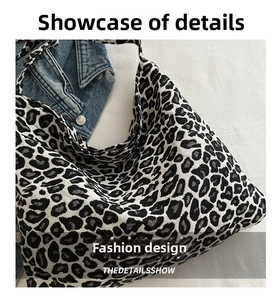 Close-up of black and white leopard print hobo tote bag in soft knit fabric texture