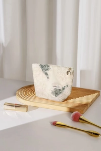 Detail view of cotton linen cosmetic bag with green leaf embroidery and gold flower zipper