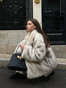 Gros plan sur la texture du manteau en fausse fourrure grise avec sac et bottines