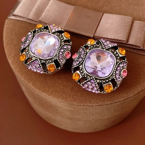 Macro shot of vintage square purple gemstone earrings with colorful rhinestones detail