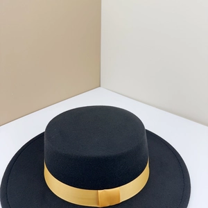 Detail of black wool felt flat top boater hat with vibrant yellow satin ribbon band