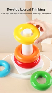 Close-up of a child stacking five colorful rainbow rings onto a sturdy white plastic base
