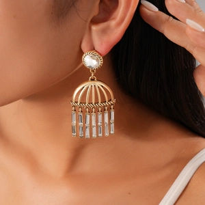 Close-up of vintage golden fringe earrings with clear crystals and tassel details