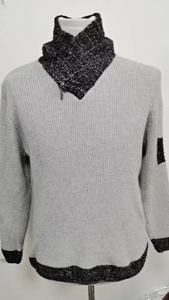 Dettaglio del maglione grigio in maglia con collo alto a contrasto e bordi a coste