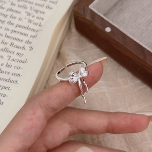 Close-up of 925 sterling silver bow open ring on an elegant vintage background