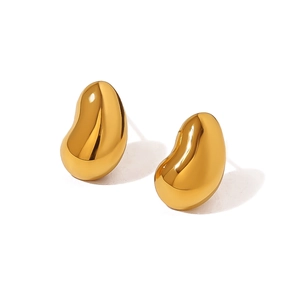 Macro view of water drop shaped stud earrings in polished golden stainless steel