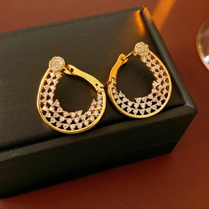 Detailed macro view of gold-plated flower hoop earrings with sparkling zircon stones