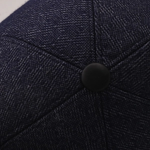 Détail de la texture textile bleu marine de la casquette avec bouton central recouvert