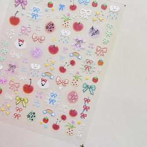 Detailed view of cute nail art stickers featuring cherry, bow, and rainbow patterns
