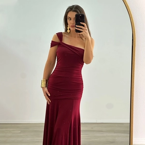 Détail de robe longue bordeaux à une épaule avec plis drapés et fente latérale