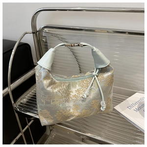 Detail of light blue jacquard handbag with traditional scenery and silver buckle