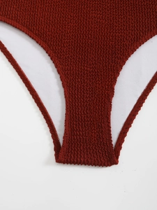 Détail d'un maillot de bain rouge foncé en tissu seersucker avec coutures soignées