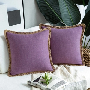 Close-up of purple linen throw pillow covers with decorative braided rope piping on sofa