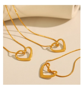 Vue détaillée du collier pendentif coeur évidé plaqué or 18 carats avec chaîne serpent fine