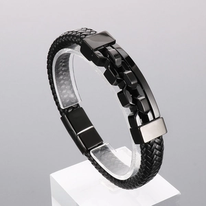 Detail of black woven leather strap and polished metal clasp on men's hip-hop bracelet