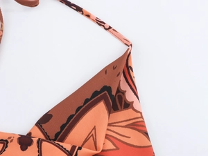 Detail view of the brown and orange print halter top with fine straps and neat stitching