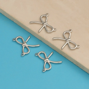 Close-up of four silver stainless steel bow-shaped jewelry connectors for DIY jewelry making