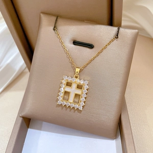 Detail of square cross pendant with mother of pearl and zircons on gold chain