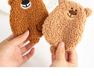 Detailed view of two soft plush bear coin purses in dark brown and light brown shades