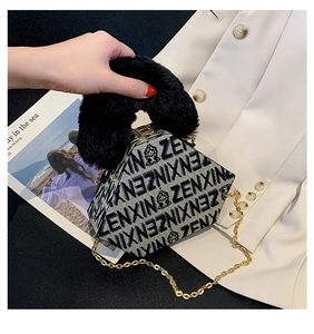 Detail of geometric handbag featuring jacquard fabric and plush faux fur handle with chain