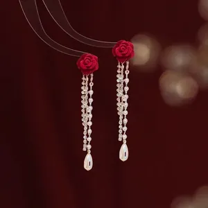 Eleganti orecchini a rosa rossa con lunghe nappe dorate e dettagli in perle