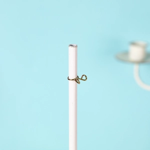 Detail of white metal rod with gold jewelry clip on a clean light blue backdrop