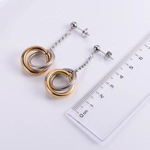 Two-tone interlocking hoop earrings in gold and silver with a measuring ruler