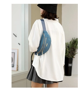Blue nylon fanny pack worn as a crossbody bag by a model over a white shirt