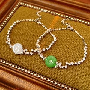 Detail of jade chalcedony bracelets with zircons on green velvet in a vintage frame