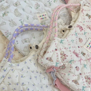 Détail du sac matelassé en toile avec motifs lapin et ours et poignées violettes