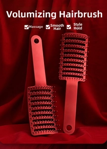 Detail of red vented hair brushes for styling on a matching silk background