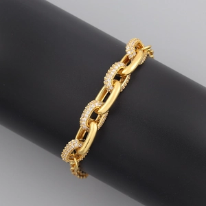 Detailed close-up of a gold hip-hop chain bracelet featuring iced-out zircon pave links