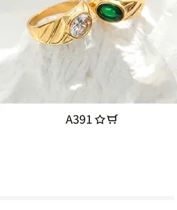 Close-up of vintage gold rings with green emerald stone and textured band details