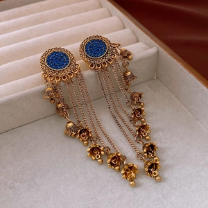Detailed close-up of gold vintage tassel earrings with blue rhinestones in a gift box